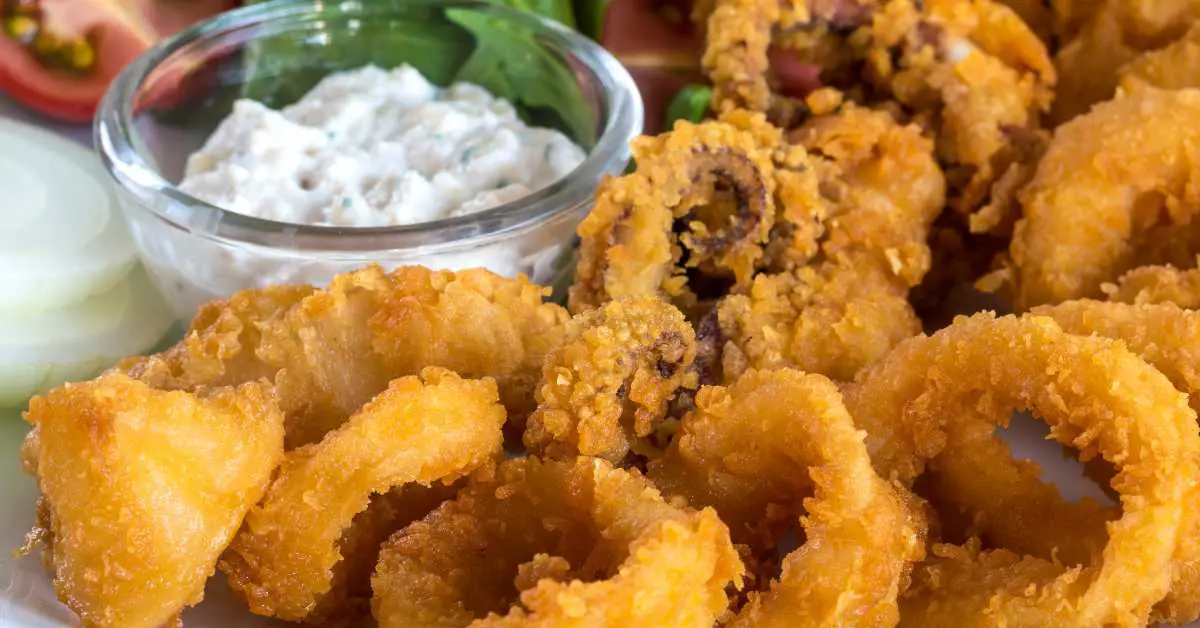 What Does Calamari Taste Like? Plate of deep fried calamari and tartar sauce