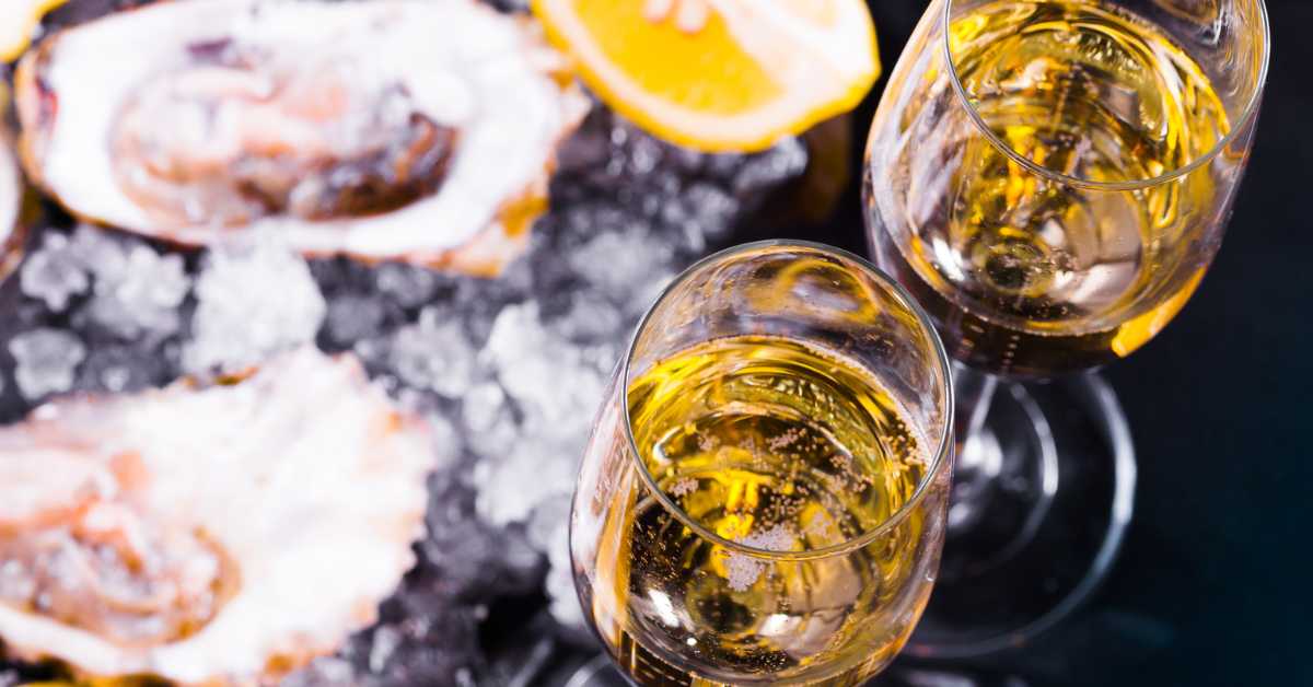 Why Oysters and Champagne Go Together So Well. Glasses of Champagne and plate of oysters